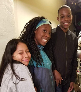 Three smiling students posing together