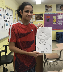student holding up a pencil drawing