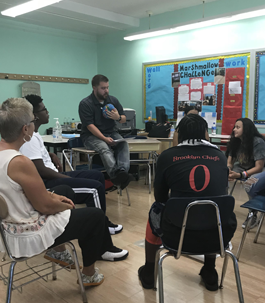 students and teacher sitting in a circle in a classroom