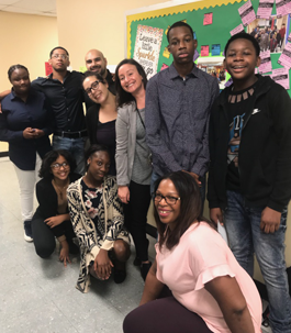 smiling students and staff members standing in a hallway