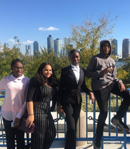 students dressed in business attire with the city skyline in the background